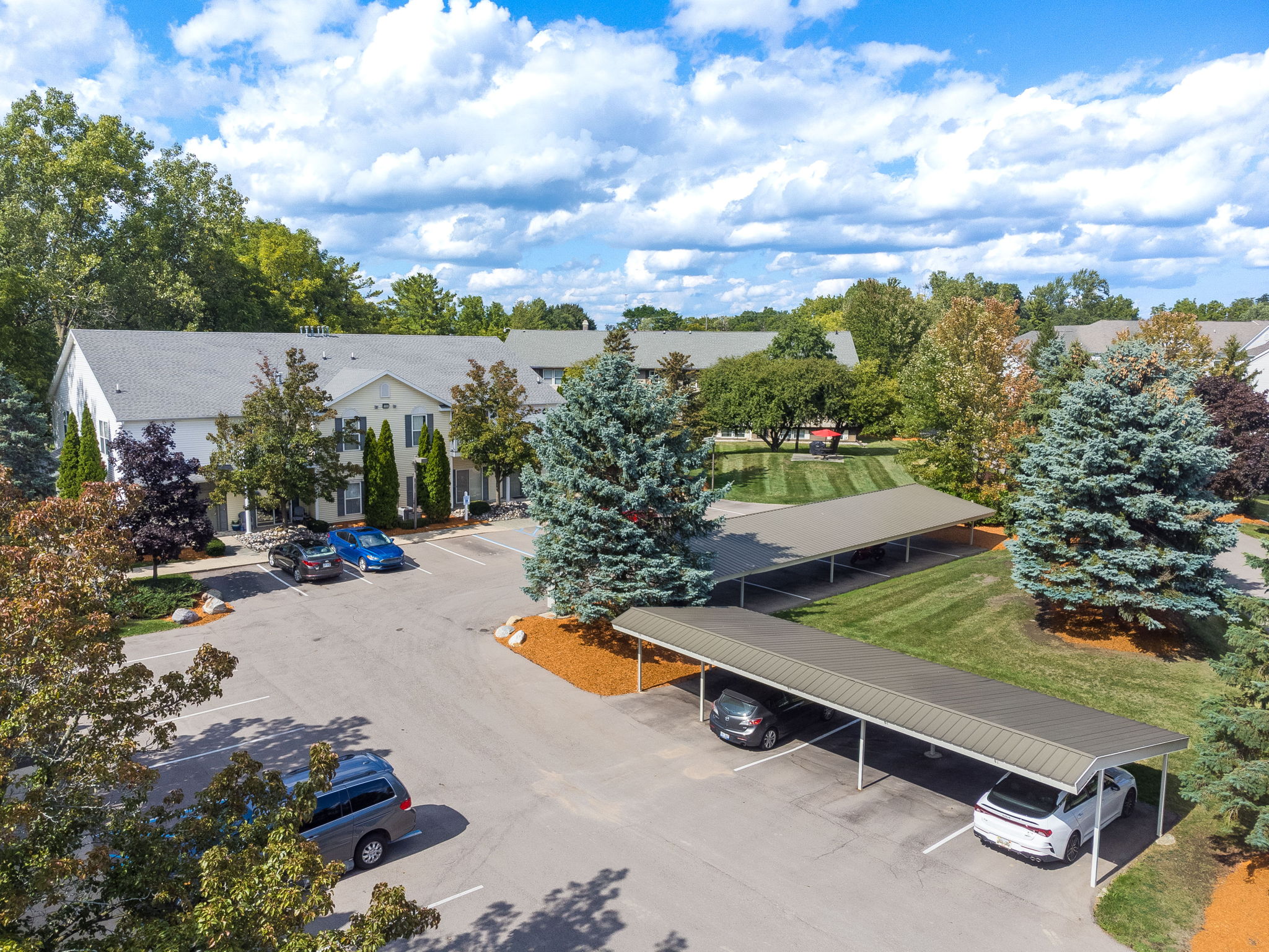 A parking lot with cars and a covered area.